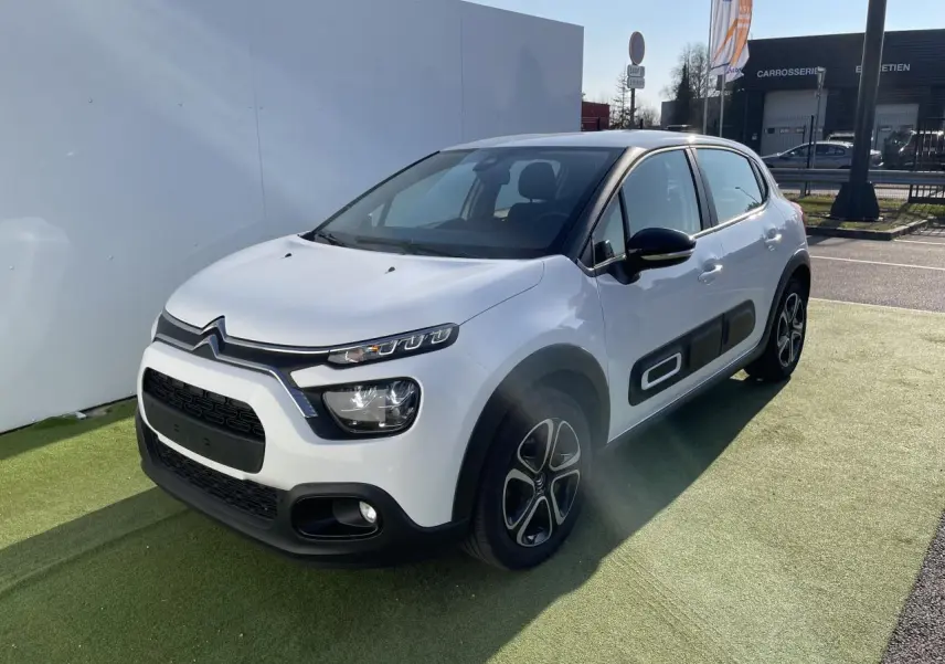 Citroën C3 blanc banquise vue 3/4 avant droit avec protections latérales noires et jantes 16 pouces design.