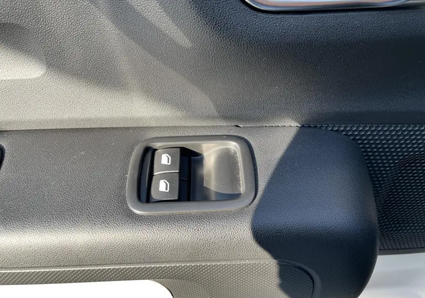 Gros plan sur les commandes de lève-vitres avant droite de la Citroën C3 blanche banquise 2024.