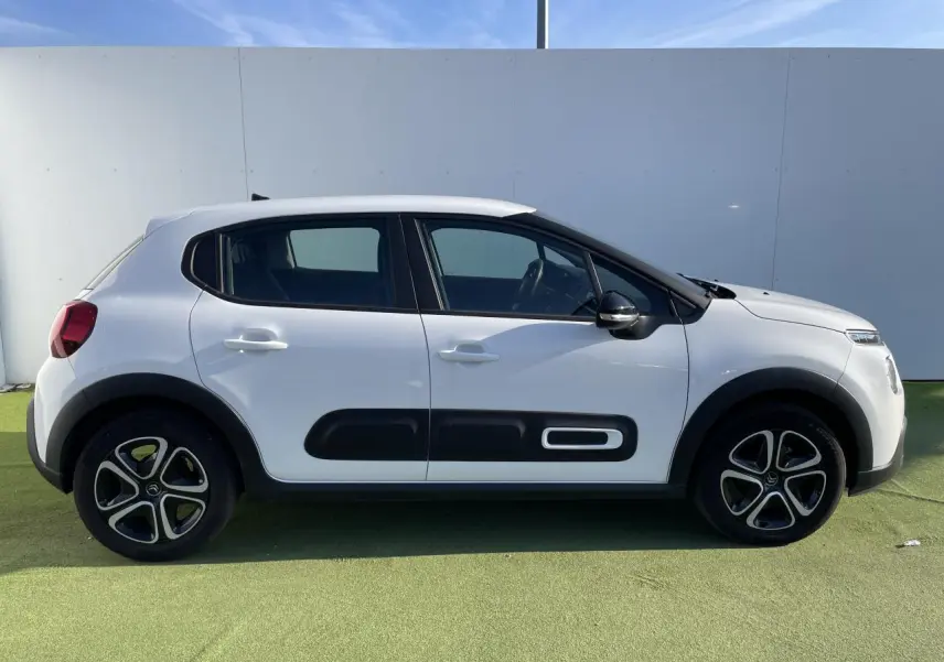 Profil droit d'une Citroën C3 blanche avec protections latérales noires et jantes originales en alliage.