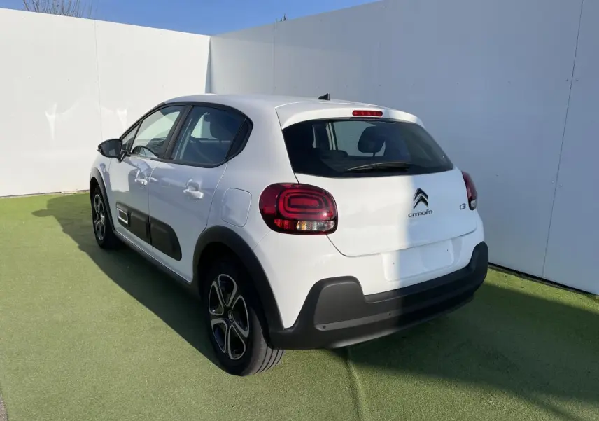 Vue 3/4 arrière droite d'une Citroën C3 blanche Banquise avec protections noires et feux arrière à effet 3D.