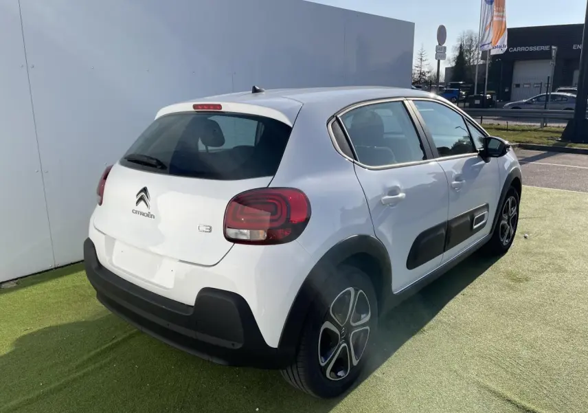 Vue 3/4 arrière droite d'une Citroën C3 blanche Banquise avec protections latérales noires et feux arrière à effet 3D.