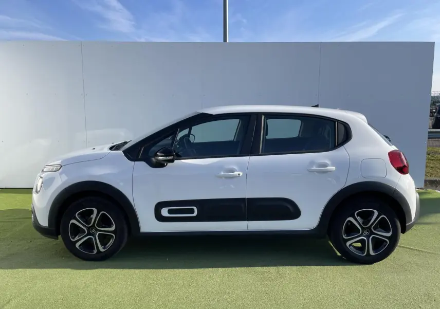 Profil côté gauche d'une Citroën C3 blanche avec protections latérales noires et jantes stylisées.