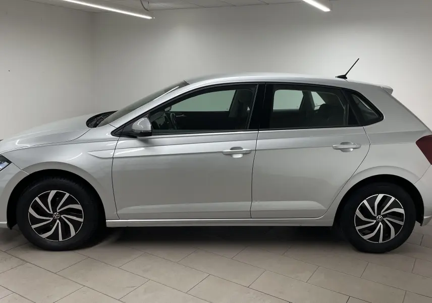 Profil côté gauche d'une Volkswagen Polo 2023 en peinture métallisée reflet d'argent avec jantes au design moderne.