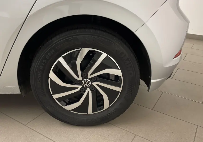 Gros plan sur la roue arrière droite d'une Volkswagen Polo 2023 en reflet d'argent avec jante alliage noire et argentée.