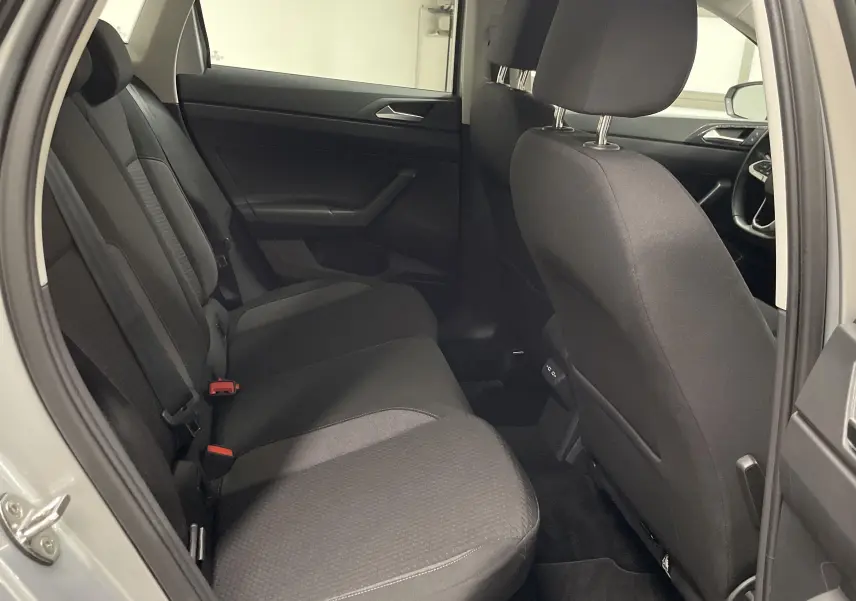 Vue intérieure côté gauche montrant les sièges arrière noirs d'une Volkswagen Polo 2023 couleur reflet d'argent.