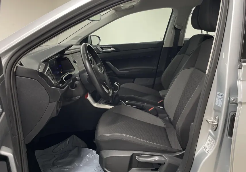Intérieur avant droit d'une Volkswagen Polo 2023 argent, montrant sièges tissu et tableau de bord moderne.