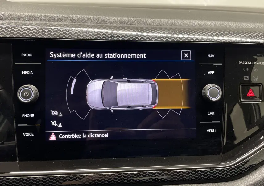 Écran central de la Volkswagen Polo 2023 montrant le système d'aide au stationnement avec alerte de distance.