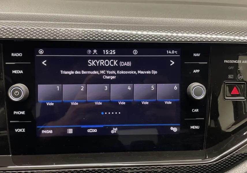 Écran tactile central de la Volkswagen Polo 2023 affichant la radio Skyrock, entouré de commandes noires brillantes.