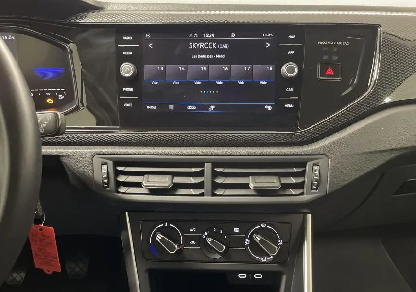 Tableau de bord de Volkswagen Polo 2023 avec écran tactile central et commandes manuelles de climatisation.