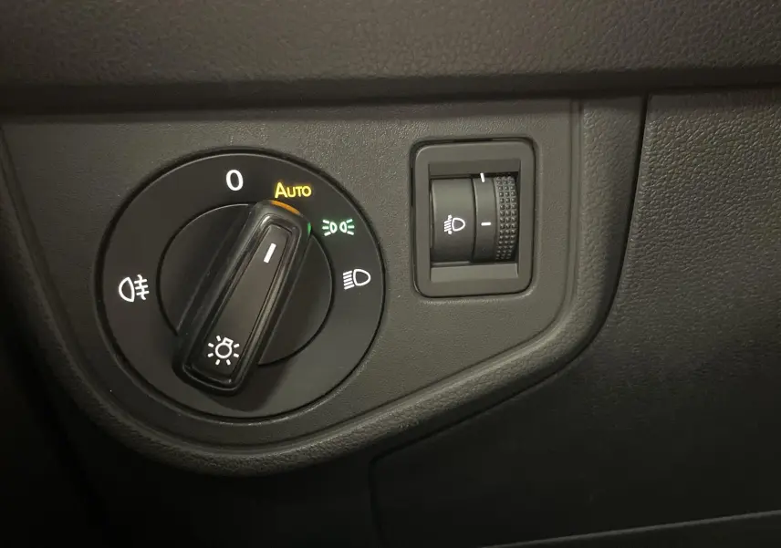 Gros plan sur le bouton de commande des phares du tableau de bord d'une Volkswagen Polo 2023 couleur reflet d'argent.