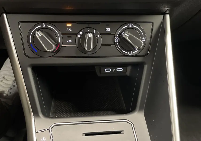 Commandes manuelles de climatisation et deux ports USB visibles sur la console centrale d'une Volkswagen Polo 2023.