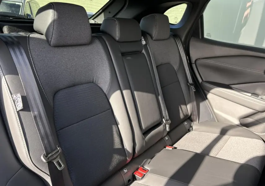 Vue intérieure côté droit des sièges arrière gris foncé du Nissan Qashqai III e-Power 2025 avec ceinture de sécurité visible.