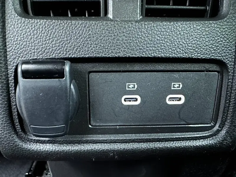 Vue rapprochée des deux ports USB-C et prise 12V sur la console centrale noire du Renault Captur gris Rafale/Noir Etoilé.