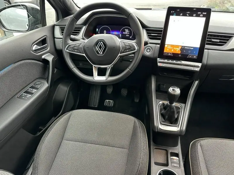 Vue intérieure avant du Renault Captur 1.0 Eco-G 100ch Techno 2025, volant multifonction, écran tactile vertical et boîte manuelle.