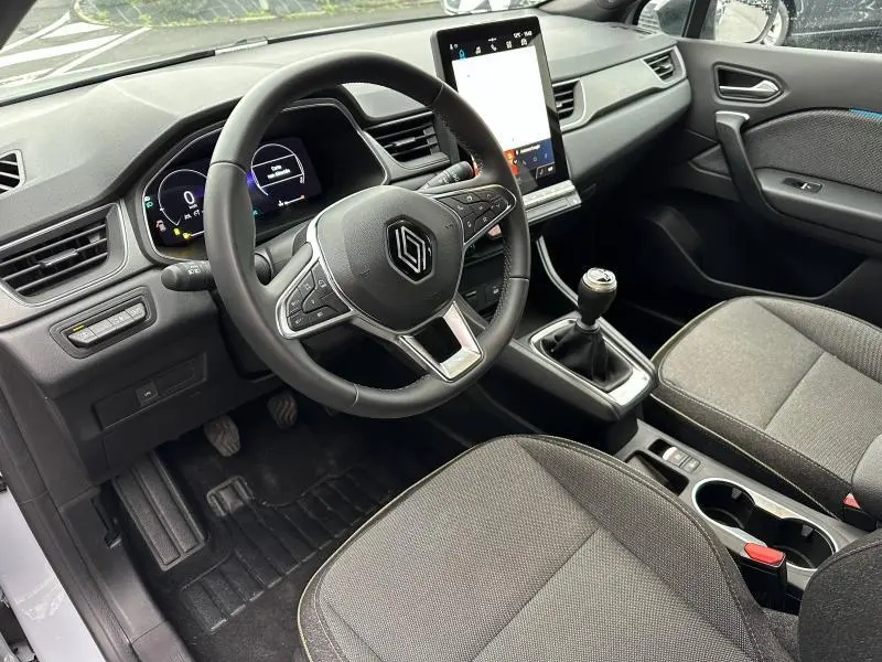 Vue intérieure côté conducteur du Renault Captur 2025 gris, volant multifonction, écran tactile vertical et boîte manuelle.