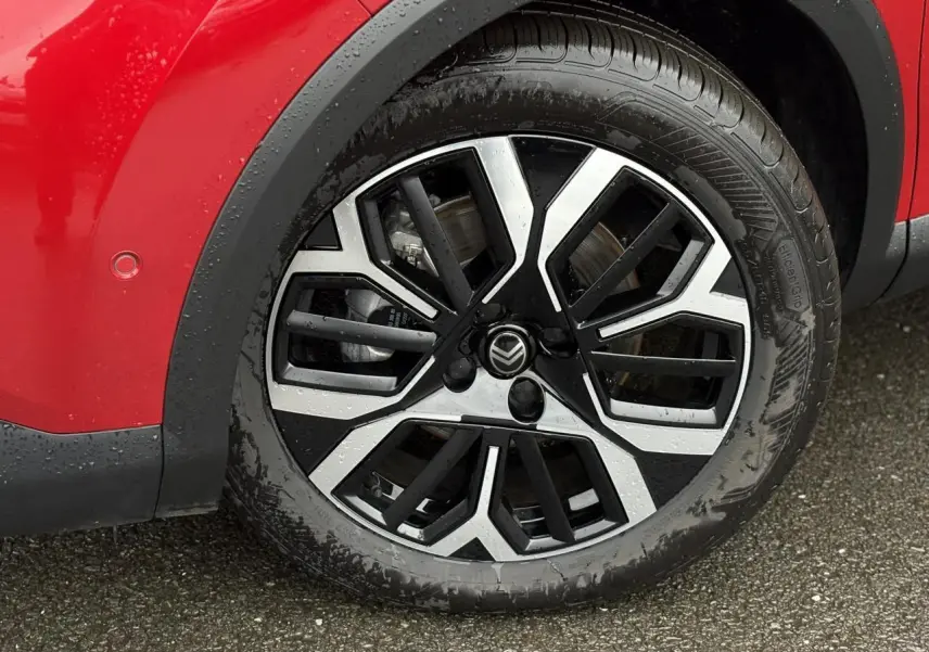 Gros plan sur la roue avant gauche de la Citroën C4 Rouge Elixir avec jante alliage diamantée noire et argentée.