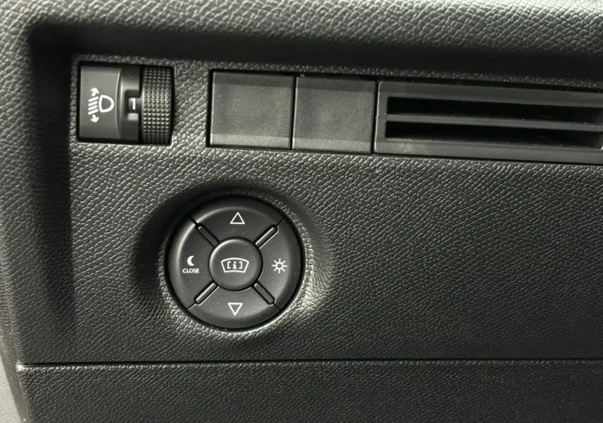Détail du tableau de bord noir texturé avec commandes d’éclairage et réglage de luminosité dans une Citroën C4.