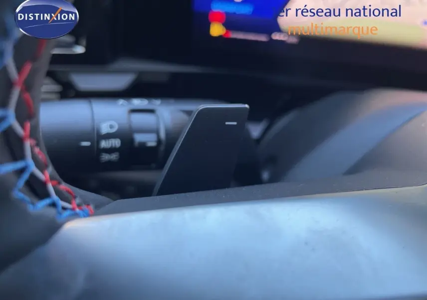 Gros plan sur le volant avec surpiqûres tricolores et commande de régulateur de vitesse du Renault Austral noir étoile métal.