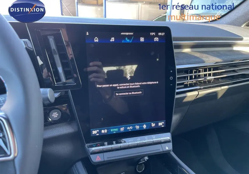 Vue intérieure centrée sur l’écran tactile vertical du tableau de bord du Renault Austral noir étoile métal, avec détails de la console et volant partiel.