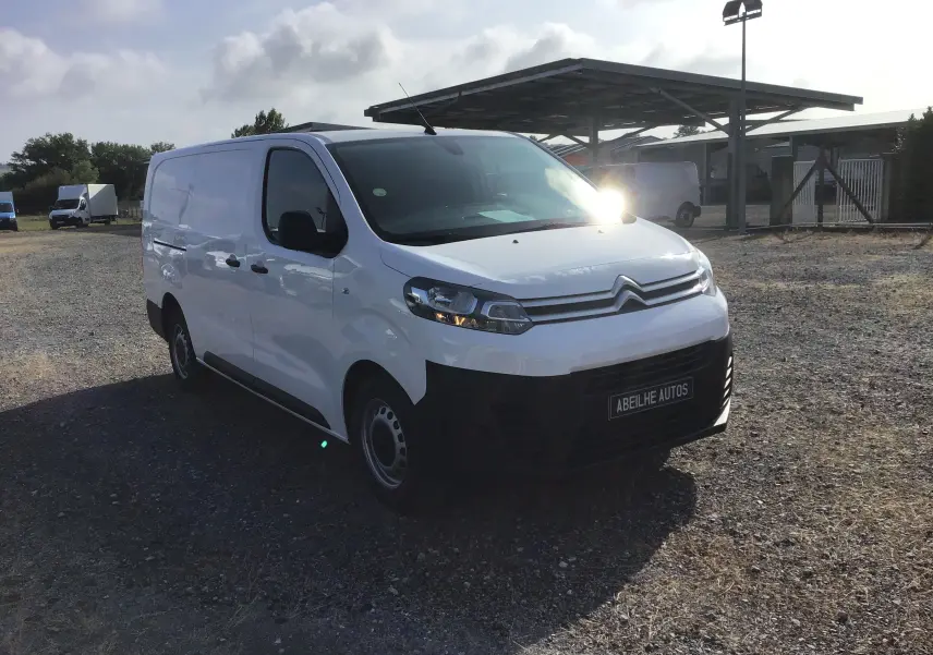 Vue 3/4 avant gauche d’un utilitaire blanc Citroën Jumpy XL 2021 avec calandre noire et jantes acier simples.