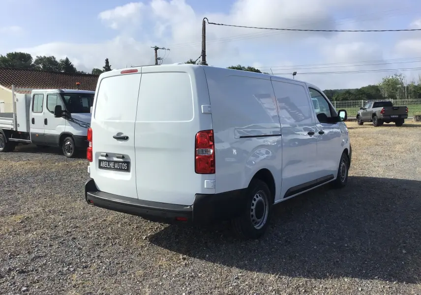 Vue 3/4 arrière droite d'un utilitaire Citroën Jumpy XL blanc, avec portes arrière pleines et pare-chocs noir.