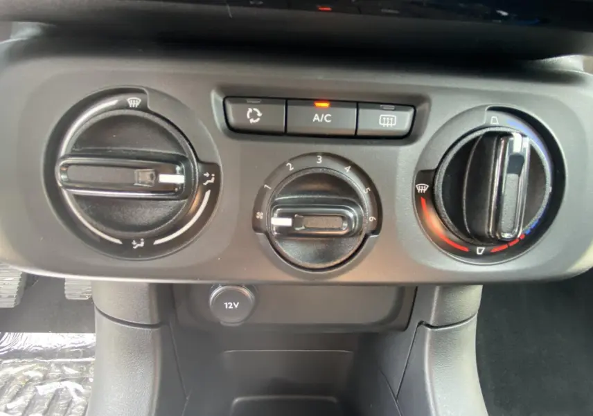Panneau de commande de climatisation manuelle avec boutons A/C et prise 12V dans une Citroën C3 blanche de 2022.
