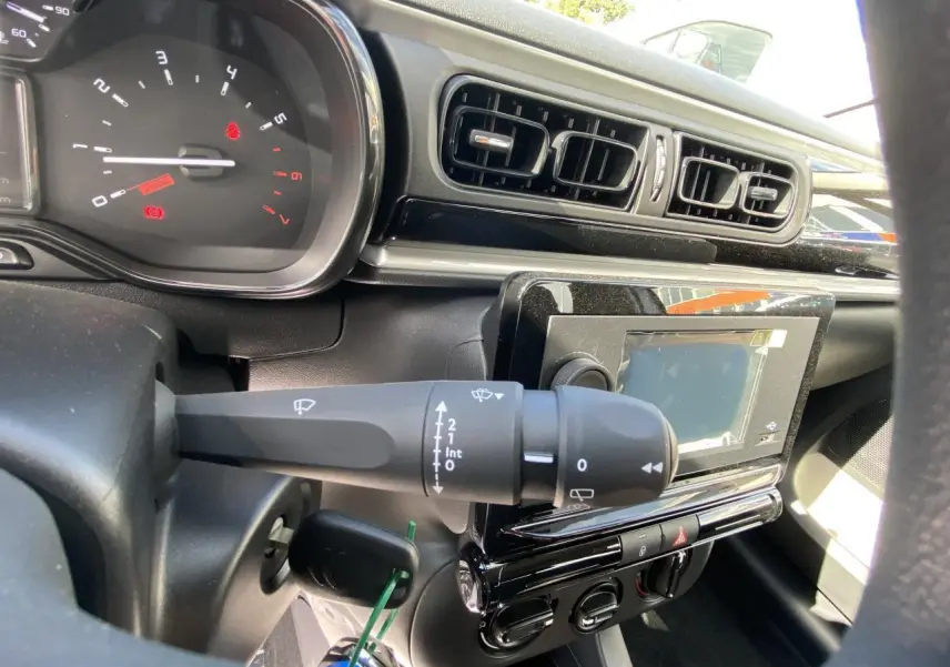 Vue rapprochée du tableau de bord noir de la Citroën C3 2022, montrant commandes d'essuie-glace et écran tactile.