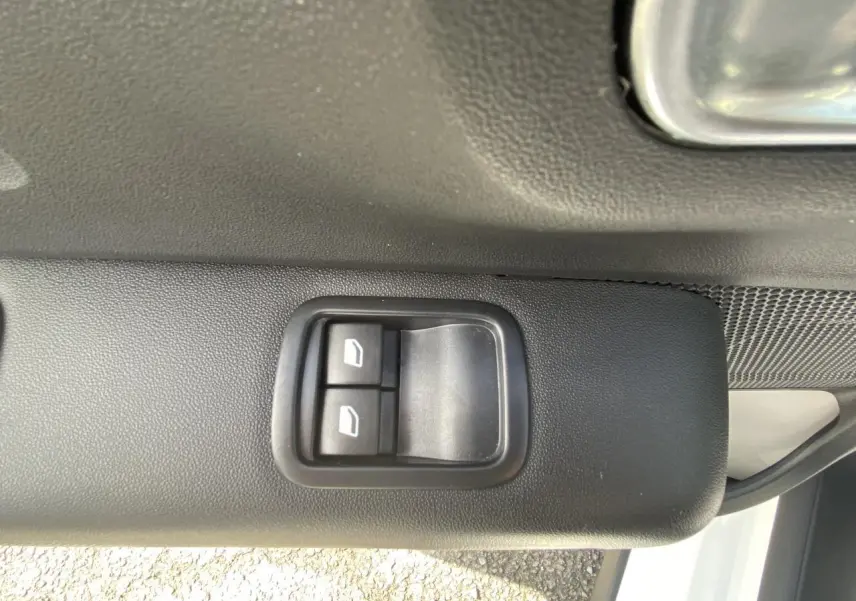 Boutons de commande des lève-vitres arrière sur la portière côté gauche d'une Citroën C3 blanche 2022.