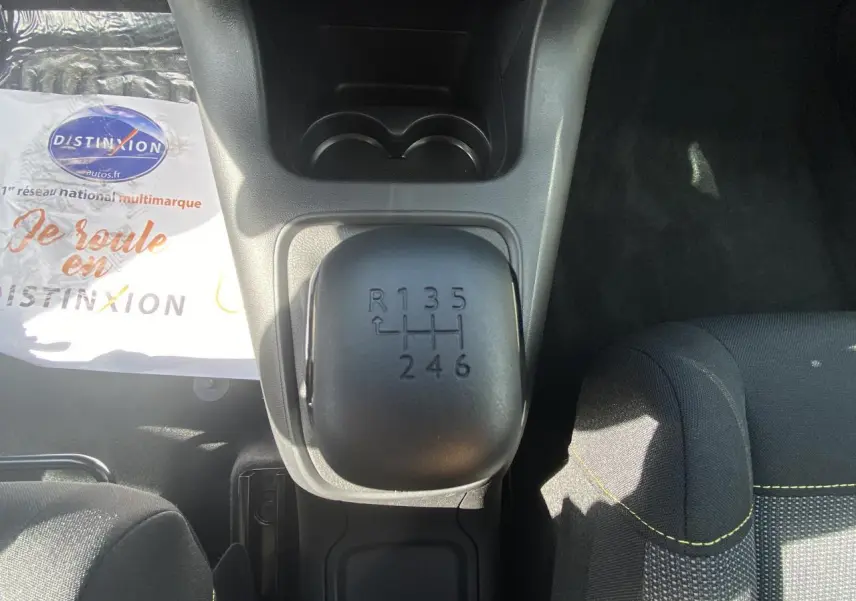 Le levier de vitesses manuel noir vu de dessus dans l'habitacle d'une Citroën C3 blanche de 2022.