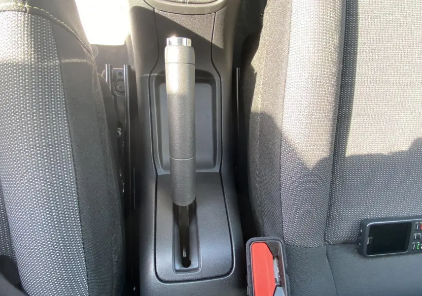 Vue rapprochée de la console centrale avec frein à main et sièges tissu gris de la Citroën C3 blanche 2022.