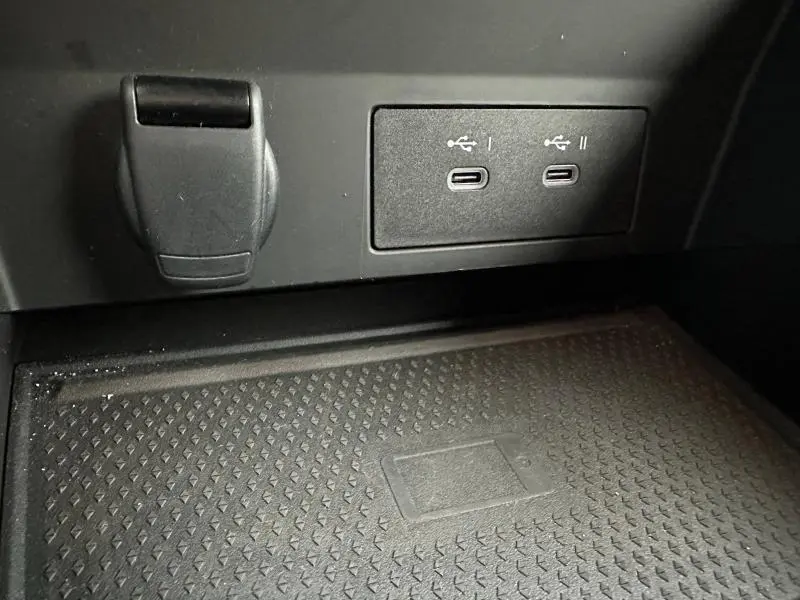 Gros plan sur la console centrale du Renault Captur 2025 montrant deux ports USB-C et un espace de recharge sans fil.