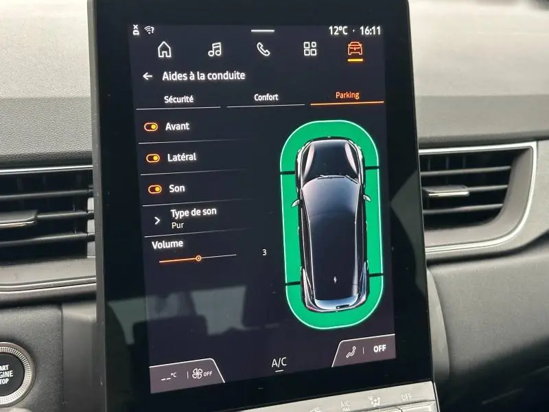 Écran tactile intérieur montrant l'aide au stationnement du Renault Captur 2025 en vue de dessus, interface noire et orange.