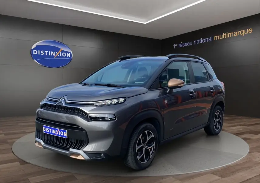 Citroën C3 Aircross gris platinium en 3/4 avant droit, avec détails bronze sur rétroviseurs et jantes noires.