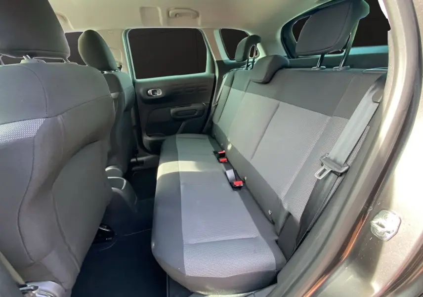 Vue intérieure du siège arrière côté droit du Citroën C3 Aircross gris platinium avec banquette tissu gris et ceintures visibles.