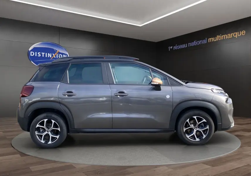 Profil côté gauche d'un Citroën C3 Aircross gris platinium avec jantes alliage et rétroviseur couleur cuivre.