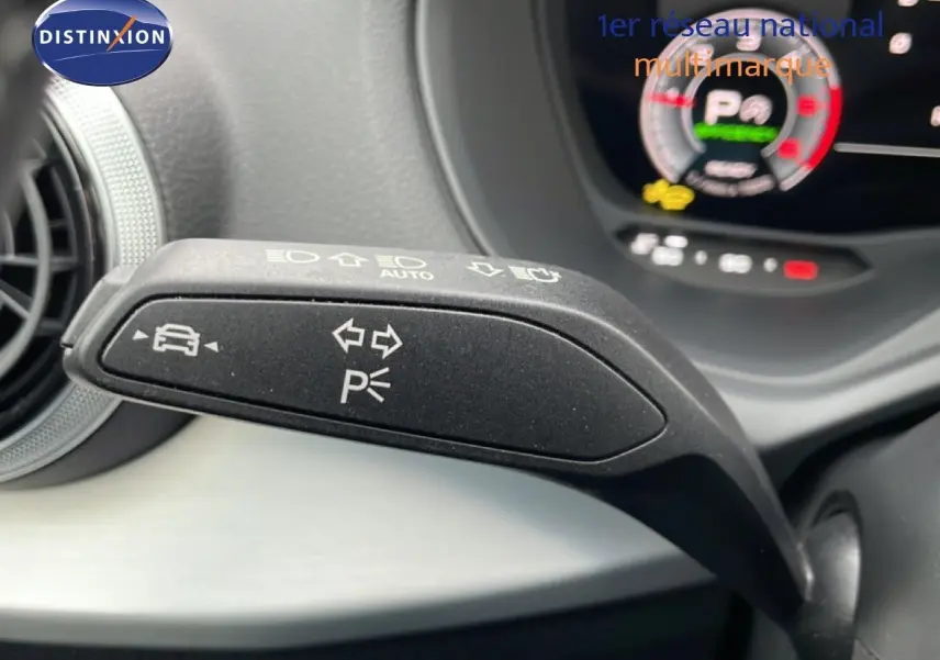 Gros plan sur la manette de clignotant et feux de stationnement dans l'habitacle d'un Audi Q2 2025 argent rose métal.