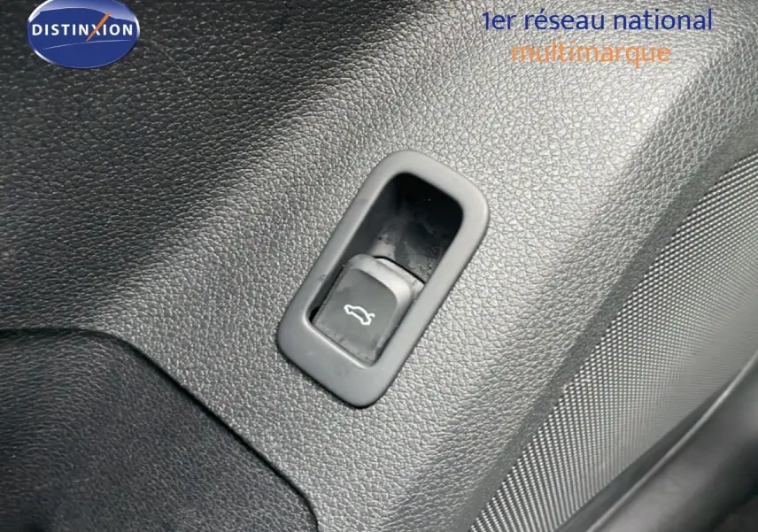 Bouton d'ouverture de coffre intégré dans le panneau intérieur noir texturé d'un Audi Q2 35 2.0 TDI S-Line.