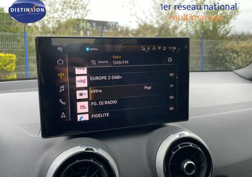 Vue intérieure du tableau de bord de l'Audi Q2 2025 avec écran tactile multimédia et aérateurs ronds argentés.