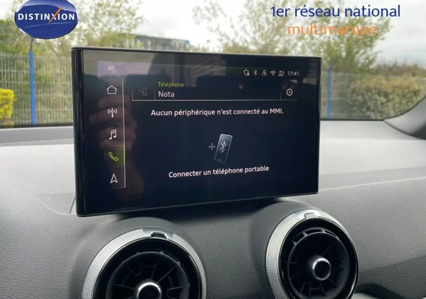 Écran tactile central affichant la connexion Bluetooth, avec deux aérateurs ronds sur tableau de bord noir.