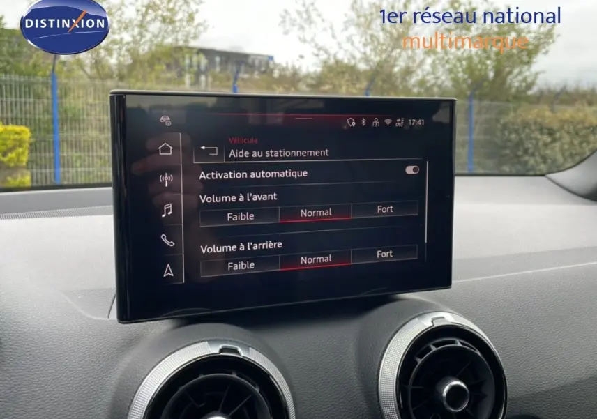Écran central affichant les réglages d’aide au stationnement dans l’habitacle d’un Audi Q2 argent rose 2025.
