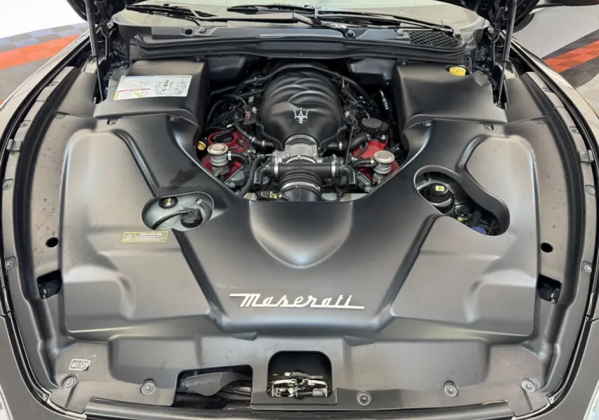 Vue plongeante sur le moteur essence gris foncé de la Maserati Granturismo S 4.7 avec logo Maserati visible.