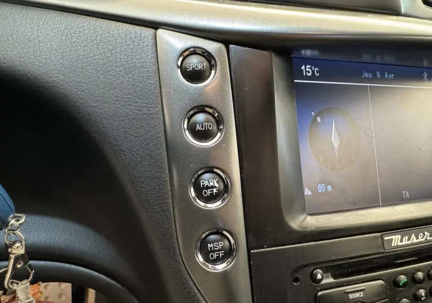 Gros plan sur la console centrale grise de la Maserati Granturismo S 4.7, montrant les boutons Sport, Auto, Park Off et MSP Off.