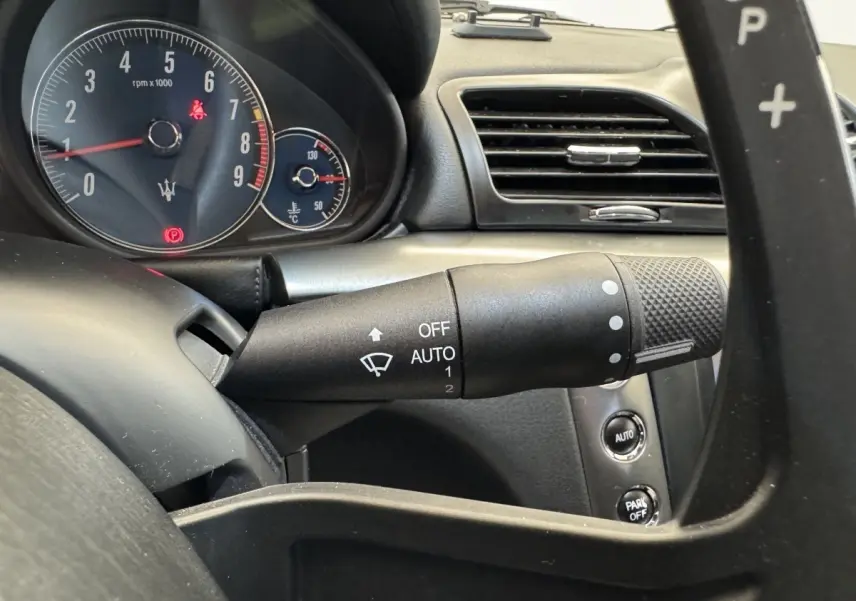 Gros plan sur le tableau de bord gris foncé de la Maserati Granturismo S 4.7, avec compte-tours et commandes au volant.