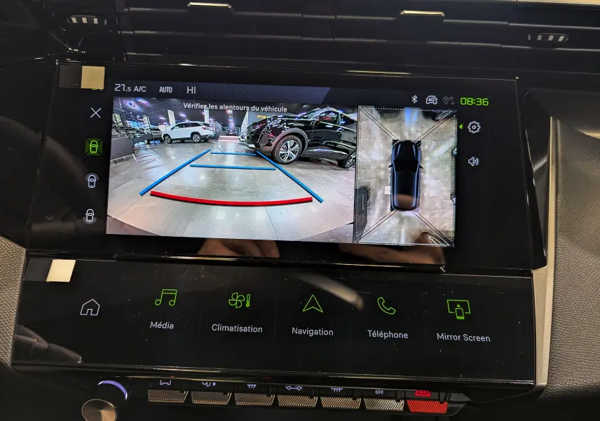 Écran central montrant la caméra de recul et vue 360° dans une Peugeot 308 GT blanche Okénite de 2024.