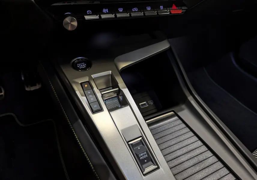 Vue rapprochée de la console centrale de la Peugeot 308 GT 2024, avec levier de vitesses automatique et boutons de commande.