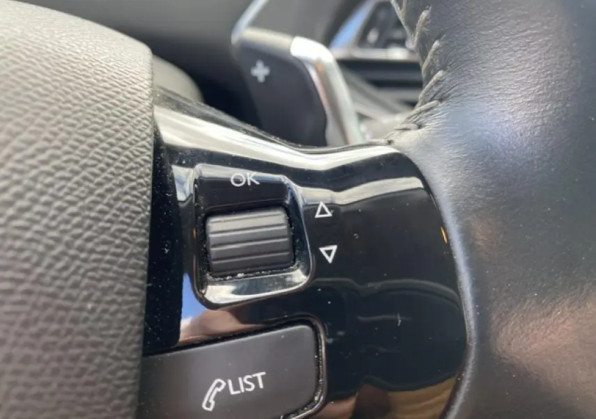 Gros plan sur les commandes au volant noir brillant du Peugeot 308 SW 2018, avec molette et bouton LIST visibles.