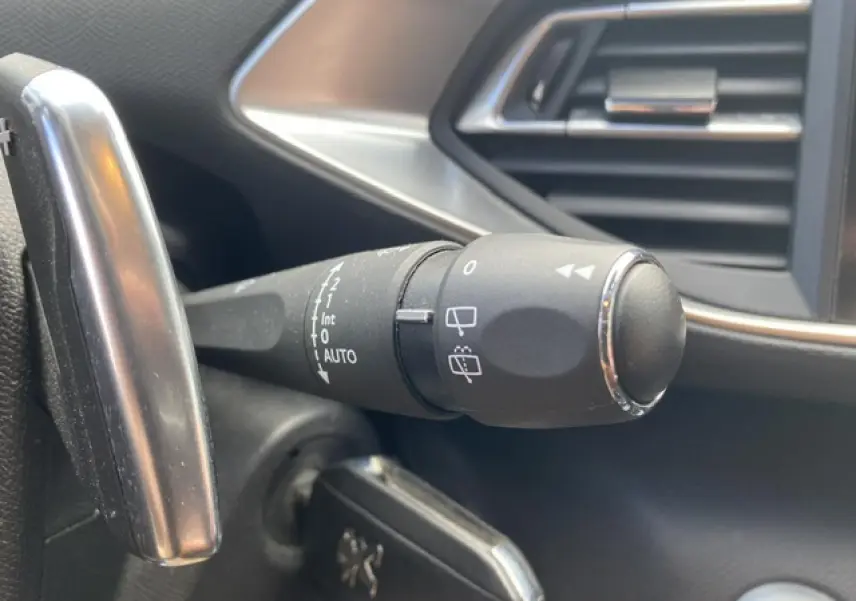 Gros plan sur la manette d’essuie-glace côté gauche du tableau de bord du Peugeot 308 SW gris Hurricane.