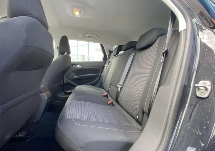 Vue intérieure côté droit sur la banquette arrière noire de la Peugeot 308 SW gris Hurricane avec porte ouverte.
