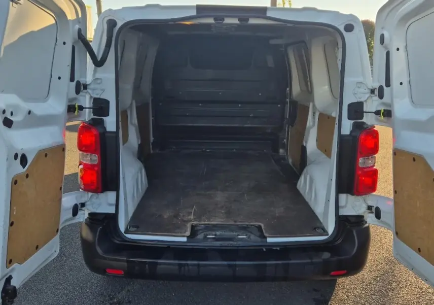 Vue arrière du Citroën Jumpy blanc 2019 avec portes ouvertes montrant l'espace de chargement vide et les feux rouges.