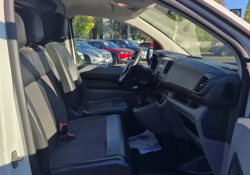 Vue intérieure côté conducteur du Citroën Jumpy blanc 2019, montrant les sièges avant et le tableau de bord.